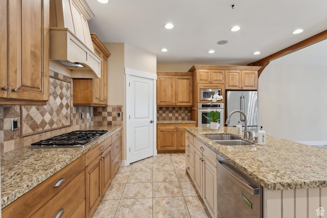 kitchen featuring a sink, stainless steel appliances, an island with sink, tasteful backsplash, and custom exhaust hood