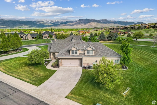 view of front of property with stone siding, a mountain view, concrete driveway, a residential view, and a garage