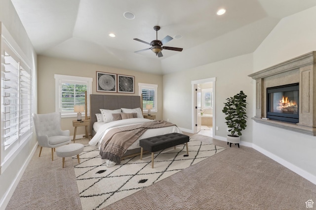 carpeted bedroom featuring a high end fireplace, vaulted ceiling, baseboards, ensuite bathroom, and recessed lighting