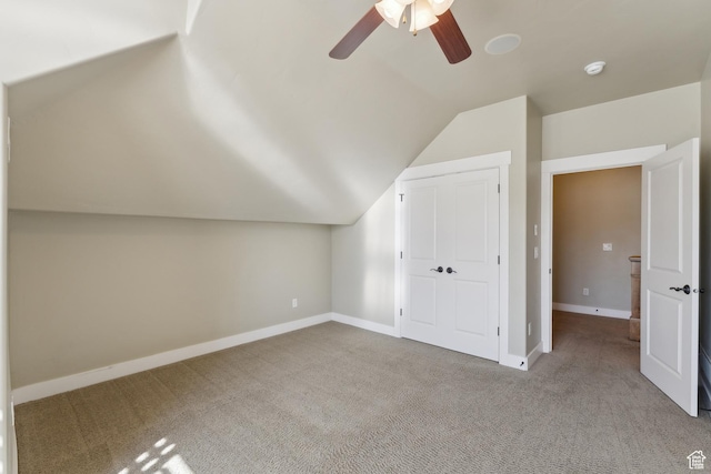 bonus room with vaulted ceiling, carpet floors, a ceiling fan, and baseboards