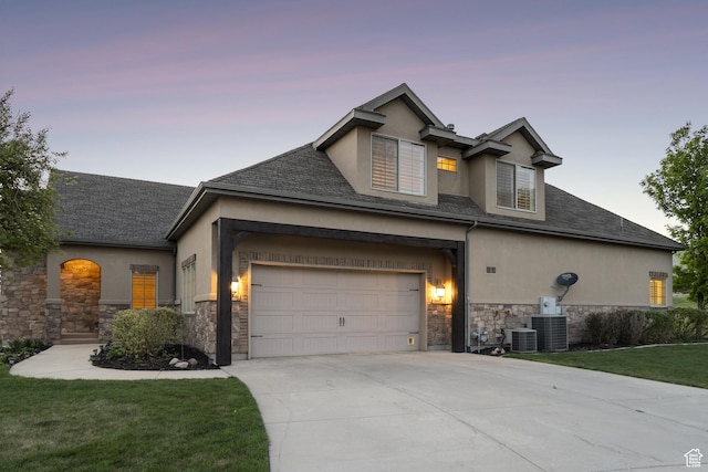 view of front of home featuring stucco siding, stone siding, driveway, and central AC unit