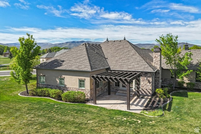 rear view of property featuring stone siding, a pergola, stucco siding, a patio area, and a lawn