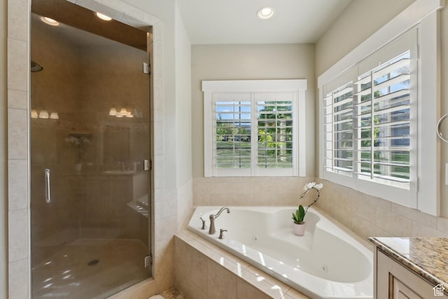 bathroom featuring a stall shower, a whirlpool tub, plenty of natural light, vanity, and recessed lighting