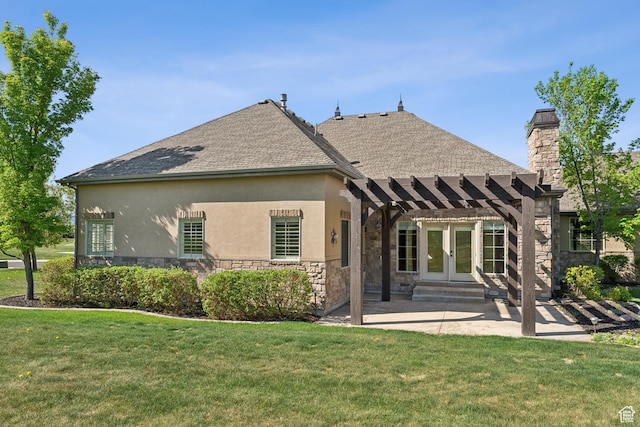 back of property with stone siding, a pergola, stucco siding, and a patio