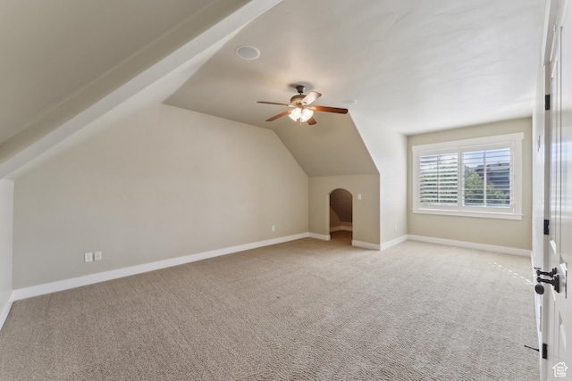 bonus room with light carpet, a ceiling fan, lofted ceiling, and baseboards