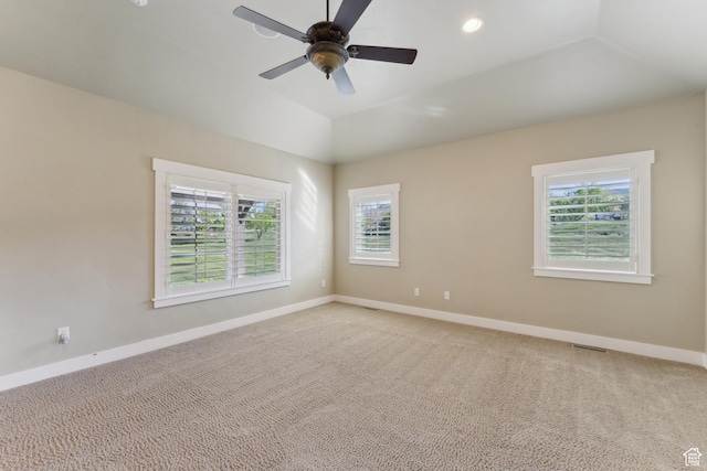 spare room with baseboards, light colored carpet, a ceiling fan, and vaulted ceiling