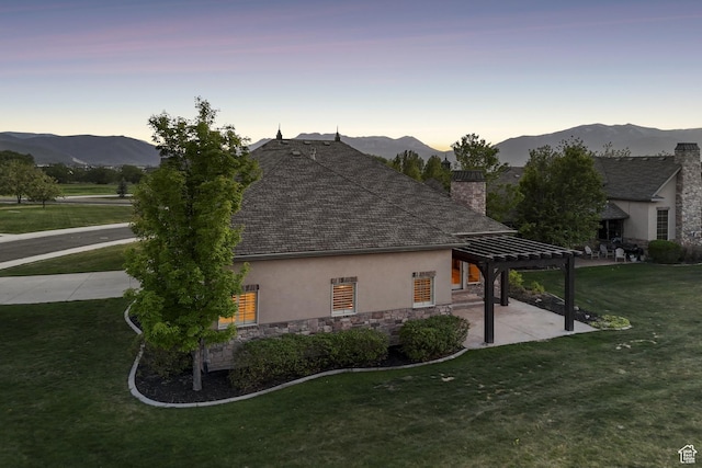 view of side of property featuring stucco siding, a pergola, a chimney, stone siding, and a patio