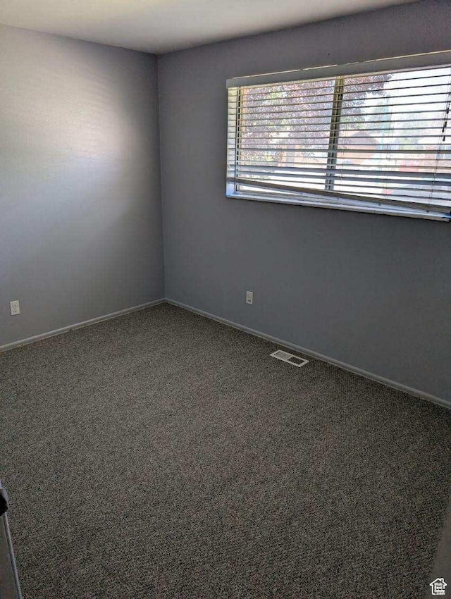 carpeted empty room featuring baseboards