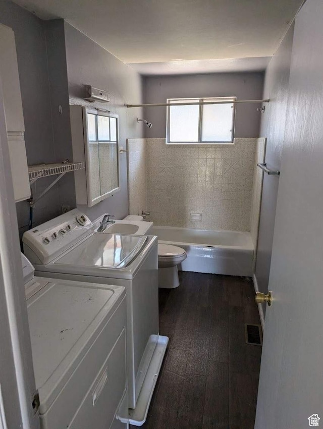 laundry area with washing machine and clothes dryer and dark wood finished floors