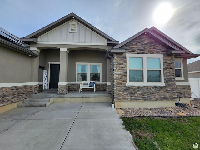 9362 N Sunnyvale Dr, Eagle Mountain, UT 84005 - view of front of house featuring stone siding, covered porch, stucco siding, and board and batten siding