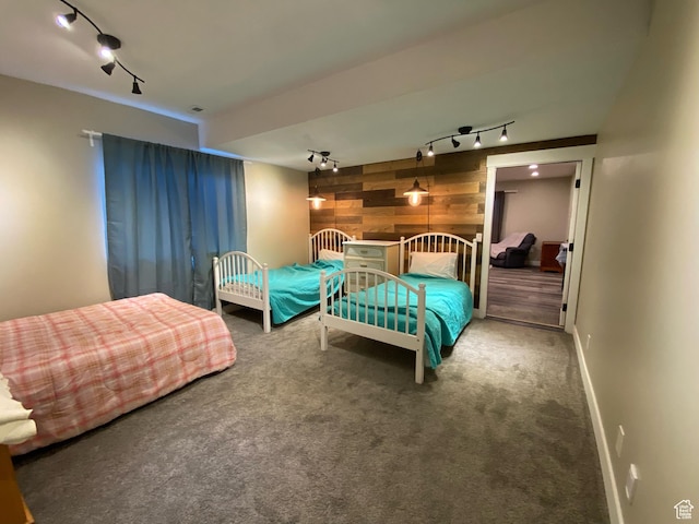 9362 N Sunnyvale Dr, Eagle Mountain, UT 84005 - bedroom with track lighting, wooden walls, carpet flooring, baseboards, and an accent wall