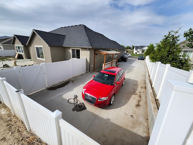 9362 N Sunnyvale Dr, Eagle Mountain, UT 84005 - view of home's exterior with roof with shingles, stucco siding, a fenced backyard, and a residential view