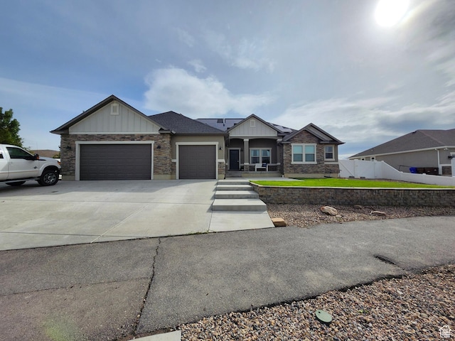 9362 N Sunnyvale Dr, Eagle Mountain, UT 84005 - craftsman-style home with an attached garage, board and batten siding, driveway, fence, and stone siding