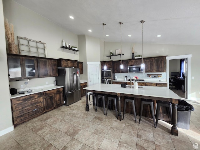 9362 N Sunnyvale Dr, Eagle Mountain, UT 84005 - kitchen with appliances with stainless steel finishes, vaulted ceiling, a kitchen bar, light countertops, and tasteful backsplash