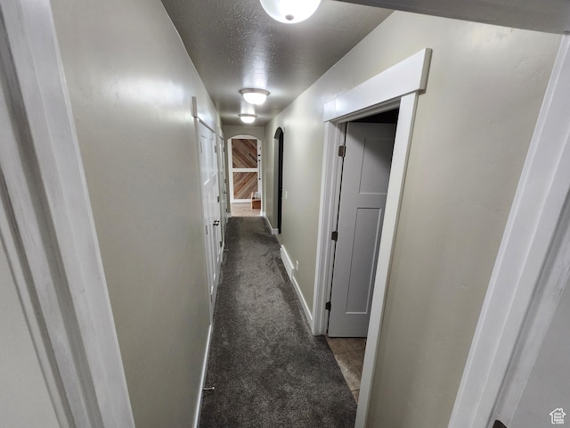 9362 N Sunnyvale Dr, Eagle Mountain, UT 84005 - hallway with arched walkways, carpet floors, a textured ceiling, and baseboards