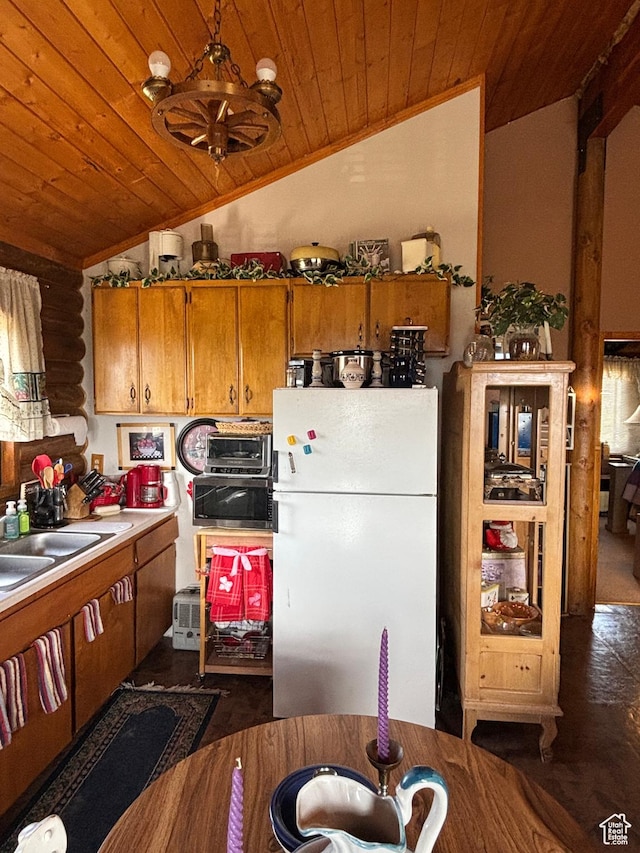 kitchen featuring freestanding refrigerator, wood ceiling, lofted ceiling, brown cabinets, and a sink