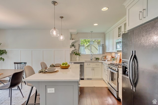 5277 S Morning Mesa Cir, Salt Lake City, UT 84123 - kitchen featuring stainless steel appliances, a sink, light countertops, hardwood / wood-style floors, and a breakfast bar area