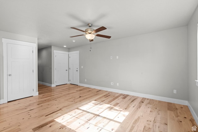 empty room with a ceiling fan, wood finished floors, and baseboards
