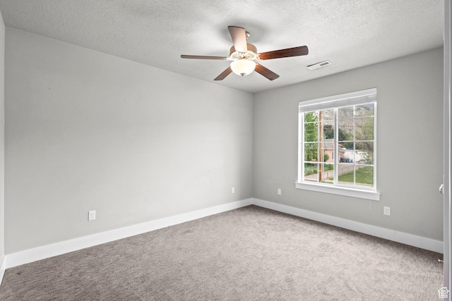 carpeted spare room featuring ceiling fan, baseboards, and a textured ceiling