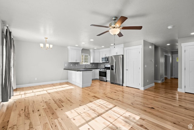 kitchen with stainless steel appliances, a chandelier, tasteful backsplash, recessed lighting, and light wood finished floors
