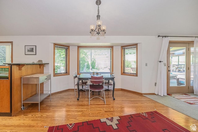 dining room with baseboards, light wood-type flooring, and a chandelier