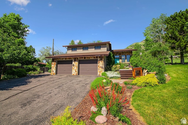view of front of property with stone siding, driveway, and a garage