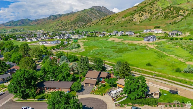 aerial view of property and surrounding area featuring nearby suburban area and a mountain backdrop