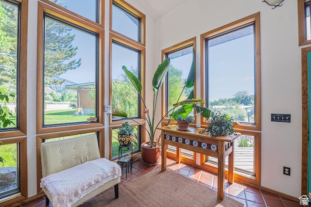 sunroom with tile patterned flooring and vaulted ceiling