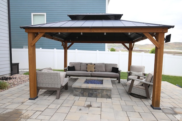 view of patio / terrace featuring a gazebo, an outdoor living space with a fire pit, and a fenced backyard