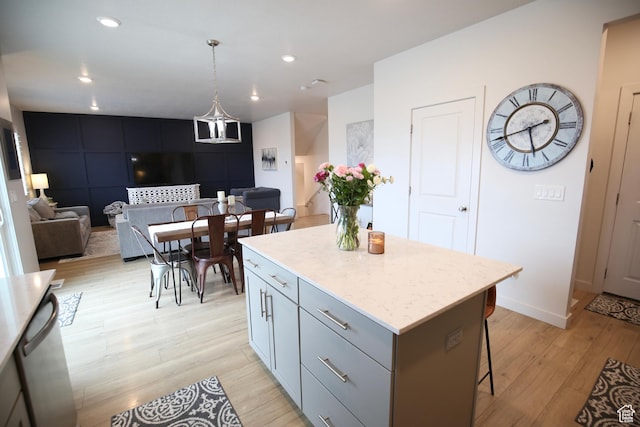 kitchen featuring a kitchen island, light wood finished floors, a breakfast bar area, recessed lighting, and stainless steel dishwasher