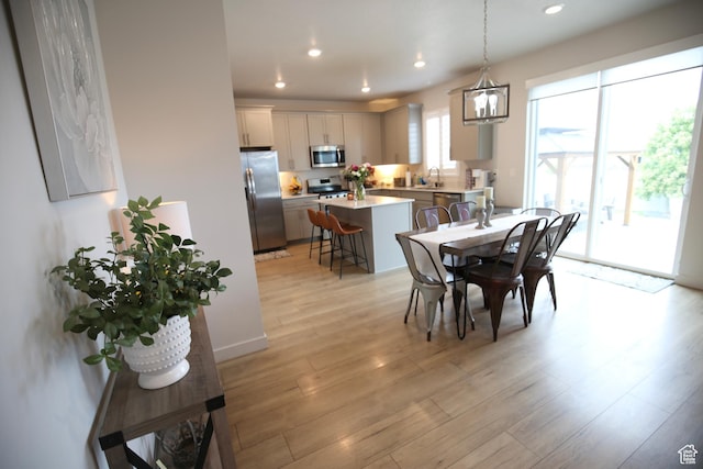 dining space with light wood-style floors and recessed lighting