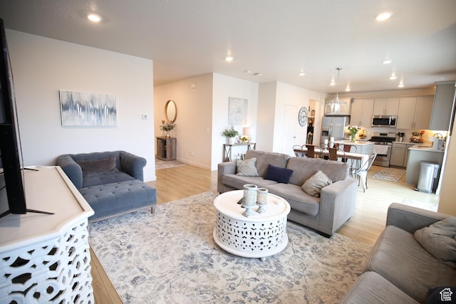 living room featuring light wood-style floors, recessed lighting, and baseboards