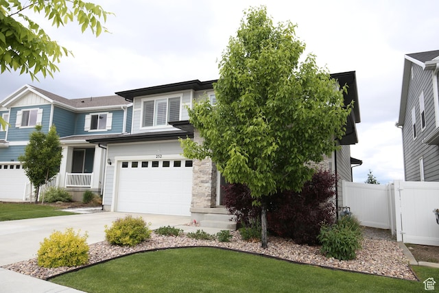 view of front of home featuring an attached garage, concrete driveway, and fence