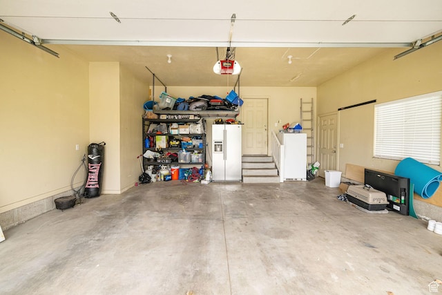 garage with white refrigerator with ice dispenser and a garage door opener