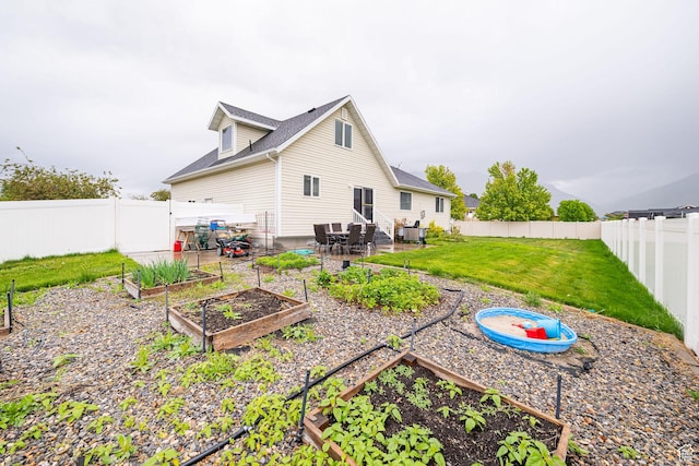 rear view of property featuring a garden
