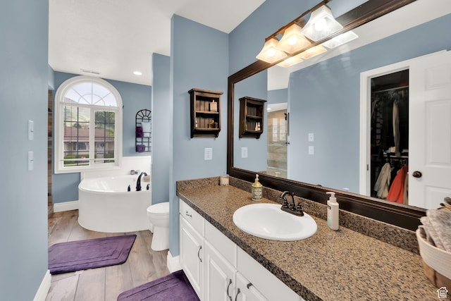 13856 S Cromwell Ln E, Draper, UT 84020 - bathroom featuring a tub, wood finished floors, baseboards, vanity, and toilet
