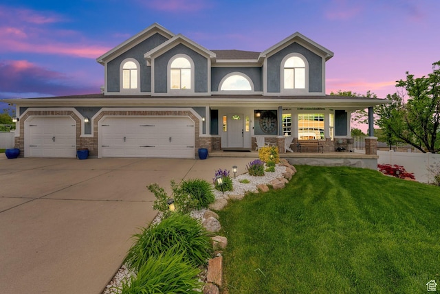 13856 S Cromwell Ln E, Draper, UT 84020 - view of front of property with a front yard, covered porch, driveway, stucco siding, and a garage