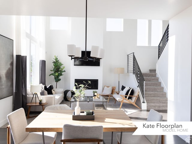 1051 N 3685 W Unit 250, Lehi, UT 84043 - living room featuring stairway, plenty of natural light, a towering ceiling, and a glass covered fireplace