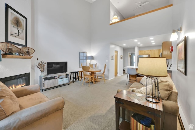 3615 N Wolf Lodge Dr Unit 1109, Eden, UT 84310 - living area featuring light carpet, a glass covered fireplace, a high ceiling, baseboards, and recessed lighting