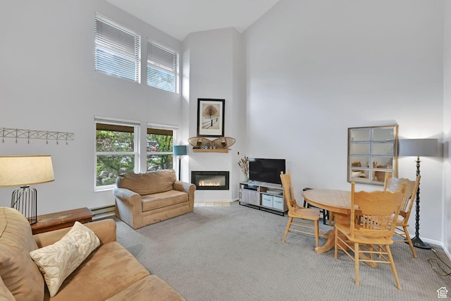 3615 N Wolf Lodge Dr Unit 1109, Eden, UT 84310 - living area featuring a high ceiling, a glass covered fireplace, a baseboard heating unit, carpet floors, and baseboards