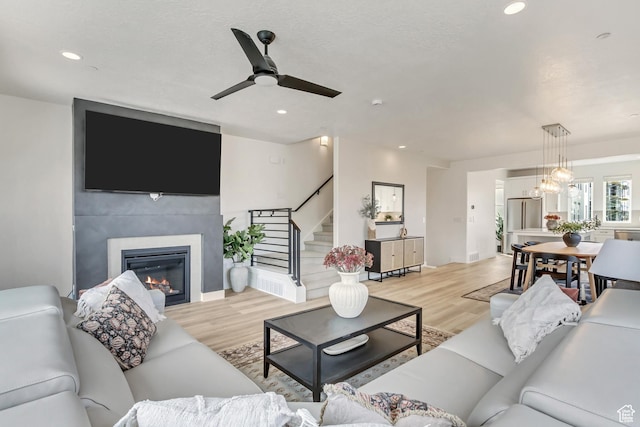 1476 W Cook Ln N Unit 162, Farmington, UT 84025 - living area with a glass covered fireplace, stairs, light wood finished floors, ceiling fan, and recessed lighting
