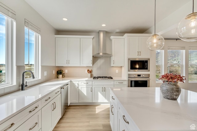 1476 W Cook Ln N Unit 162, Farmington, UT 84025 - kitchen featuring appliances with stainless steel finishes, wall chimney range hood, plenty of natural light, light wood-style floors, and recessed lighting