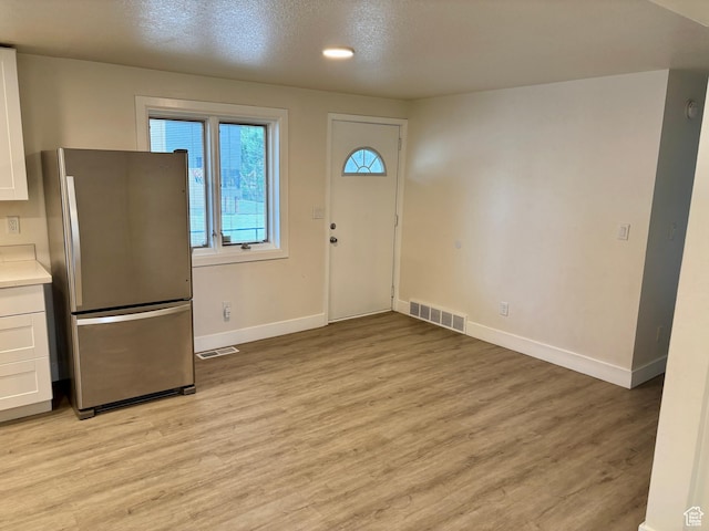 foyer entrance featuring baseboards and light wood finished floors