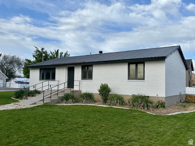 single story home with a front lawn and metal roof
