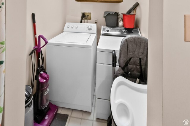 clothes washing area featuring separate washer and dryer and light tile patterned floors