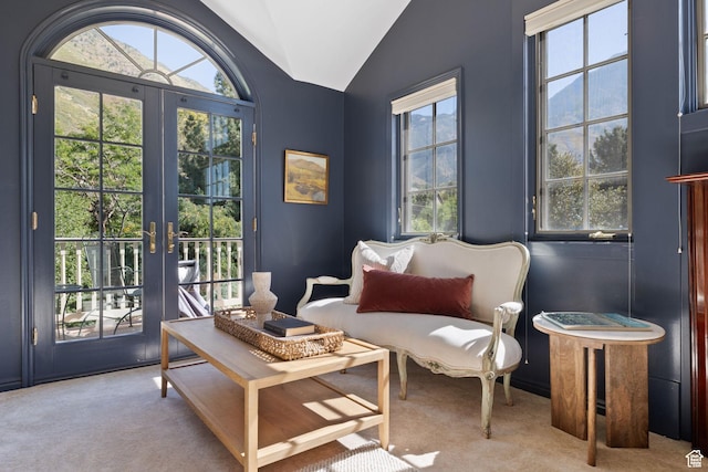 living area featuring carpet, lofted ceiling, and french doors