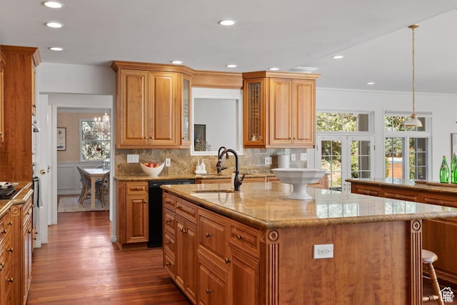 kitchen featuring a sink, dishwasher, dark wood-style floors, a kitchen island with sink, and glass insert cabinets