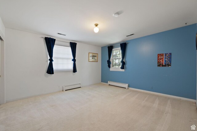 carpeted spare room with a baseboard heating unit and baseboards
