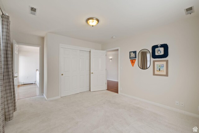 unfurnished bedroom with carpet, baseboards, and a closet