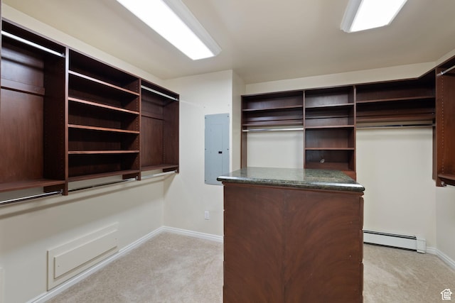 walk in closet featuring baseboard heating, light colored carpet, and electric panel